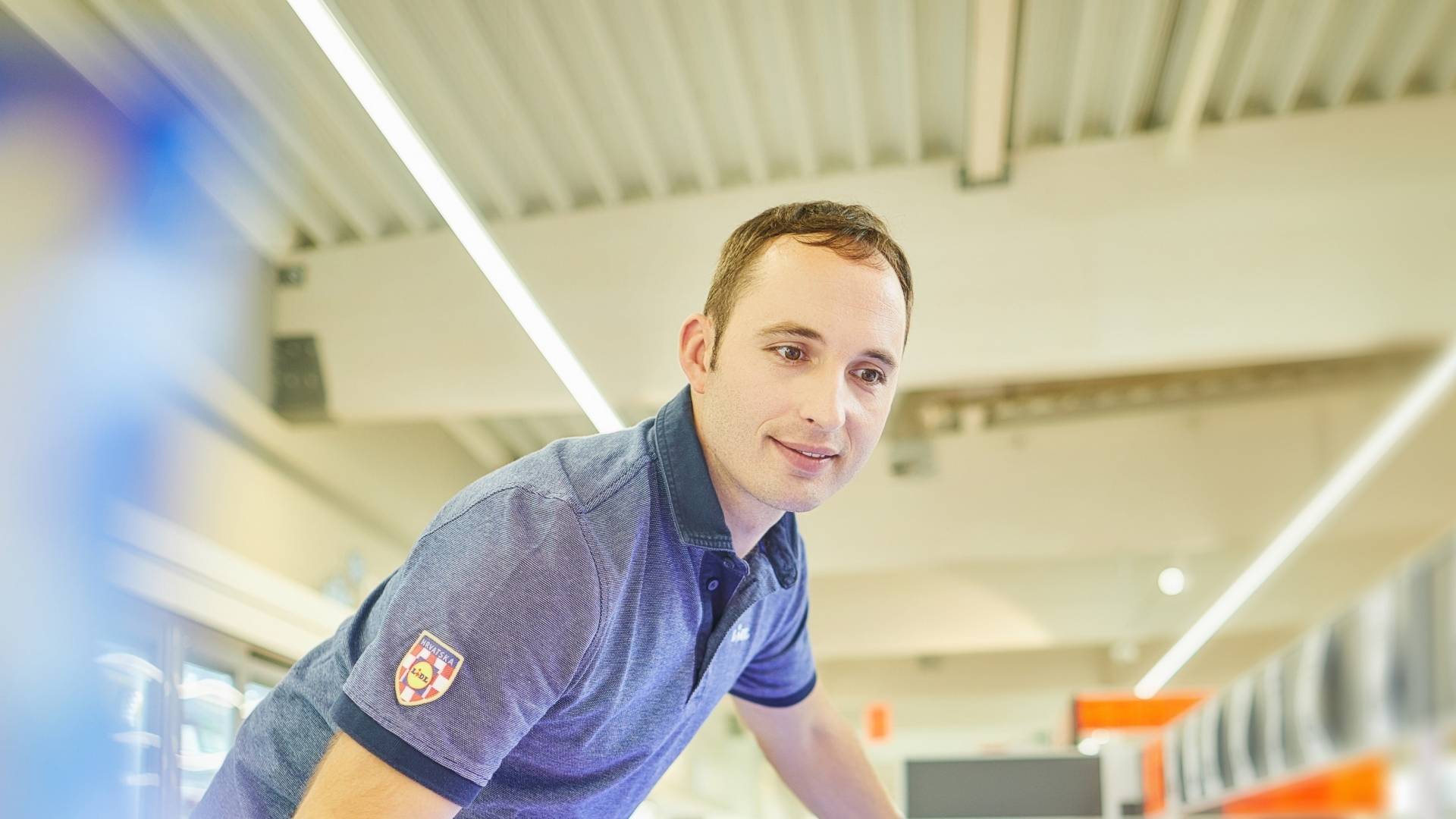 Prodavač slaže robu u rashladnu vitrinu